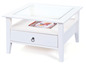 Table basse blanche avec plateau en verre et tiroir.