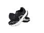 Chaussures de sport noires avec des lacets gris et des semelles blanches.