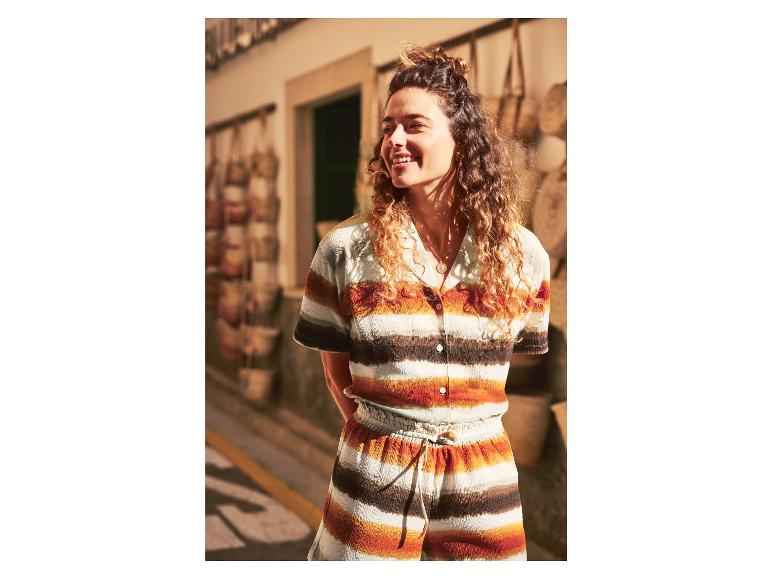 Une femme portant un haut et un pantalon rayés dans un magasin avec des sacs faits main.