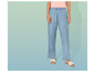 Une femme portant un pantalon bleu clair et des sandales blanches.