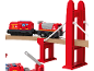 Train de pompiers jouet rouge sur des rails en bois traversant un pont rouge.