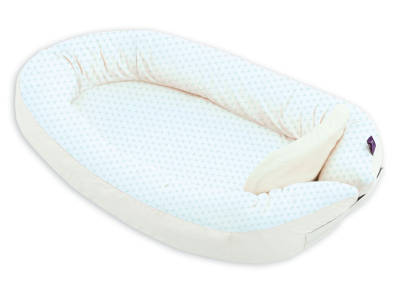 Un nid pour bébé avec un motif blanc et vert.