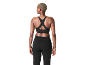 Femme de dos portant un soutien-gorge de sport noir et un pantalon de sport noir.