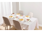 Table élégamment dressée avec des bols de soupe et de dessert sur une nappe blanche.