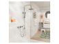 Ensemble de douche chromé avec pommeau de douche pluie et douchette, sur carrelage blanc dans la salle de bain.