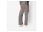 Une femme porte un pantalon gris et des baskets blanches.