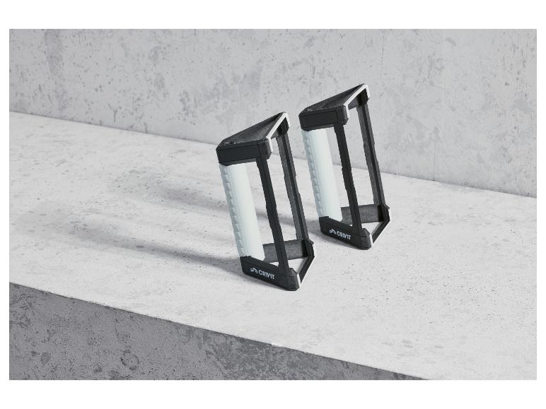Deux barres de pompes noires Crivit sur une surface en béton.
