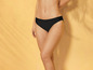 Une femme portant un bas de bikini noir.