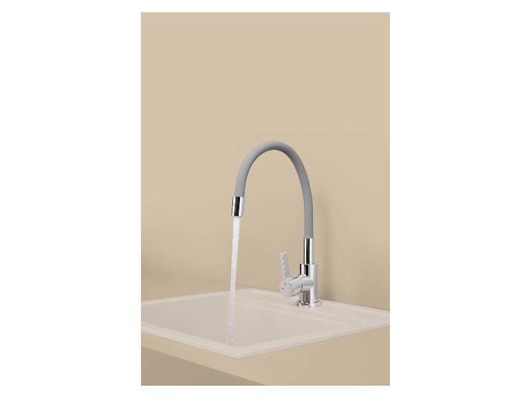 Robinet de cuisine avec bec flexible gris et eau courante sur un évier beige.