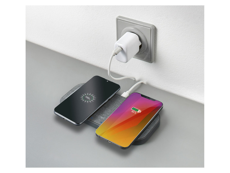 Deux smartphones se chargent sur un chargeur sans fil.