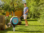Un homme arrose le jardin avec un tuyau d'arrosage Gardena.