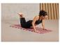Une femme faisant des pompes sur un tapis de yoga Sport rose.
