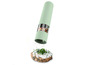 Un moulin à poivre vert saupoudrant du poivre sur un cracker avec du fromage à la crème.