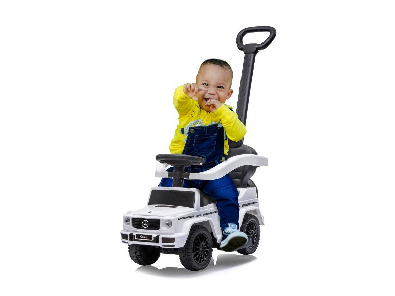 Un jeune enfant s'amuse avec une voiture jouet Mercedes-Benz Classe G.