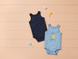 Deux bodies pour bébé, un bleu marine et un bleu clair avec un soleil.