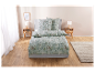 Parure de lit fleurie vert clair dans une chambre moderne.
