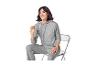 Femme souriante en sweat à capuche côtelé gris et pantalon assorti, assise sur une chaise