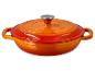 Cocotte Staub en fonte orange avec couvercle.