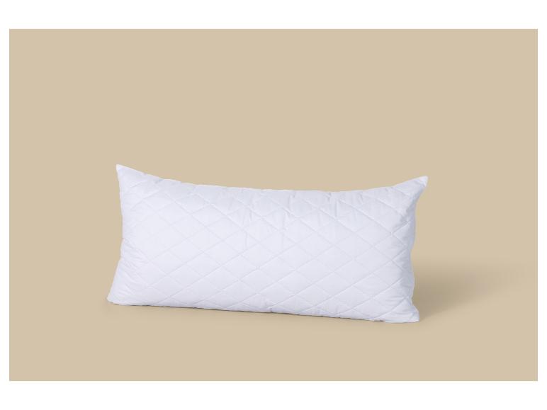 Oreiller blanc matelassé sur fond beige