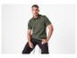Homme en polo vert foncé et pantalon noir, assis sur un tabouret.
