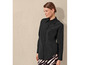 Une femme porte une chemise noire à manches longues et un pantalon rayé.