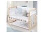 Lit bébé en bois avec literie blanche à motifs d'étoiles et oreillers lune