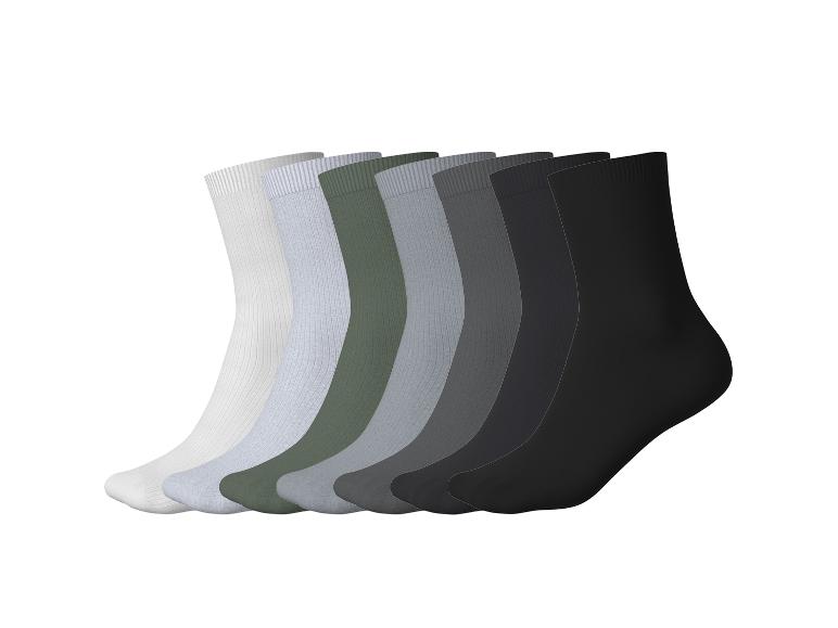 Sept paires de chaussettes de différentes couleurs, du blanc au noir, avec une texture côtelée