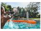 Deux amis jouent au volley-ball aquatique avec un filet gonflable orange dans une piscine.