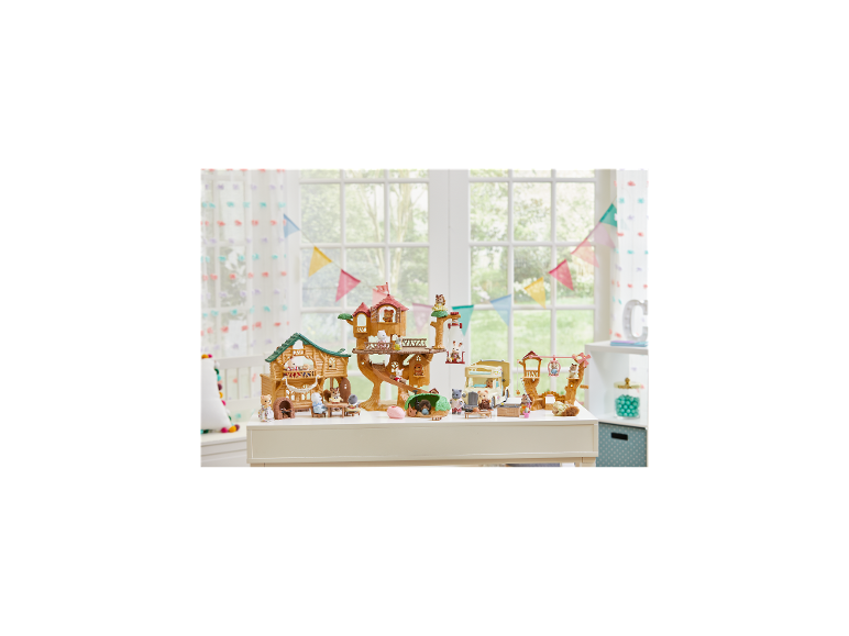 Ensemble de jeu pour enfants avec cabane dans les arbres, figurines d'animaux et camping-car sur une table blanche.