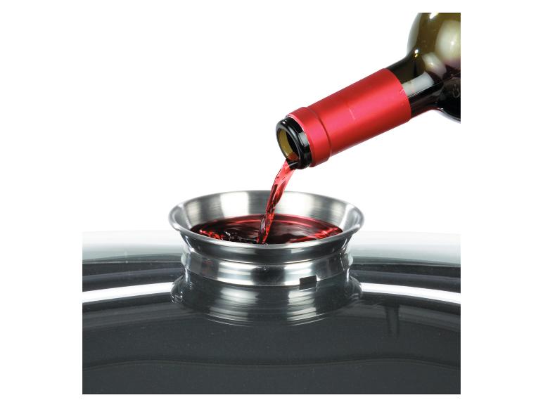 Une bouteille de vin est versée dans un bol en verre.