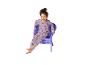 Fille en pyjama rose licorne assise et riant dans un fauteuil violet.