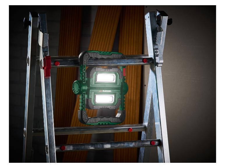 Lampe de travail PARKSIDE sur une échelle, éclairant un fond sombre.
