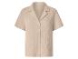 Chemise boutonnée beige clair à manches courtes et col camp, en tissu froissé.