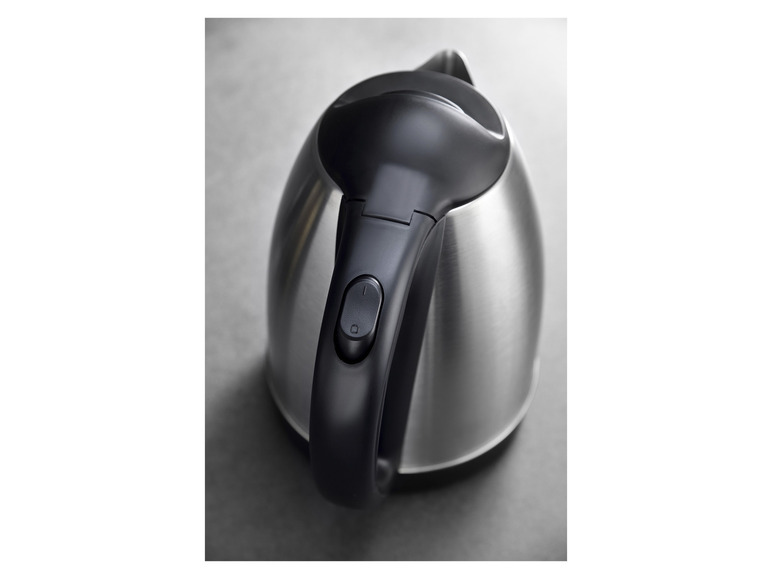 Gros plan sur une bouilloire en acier inoxydable avec une poignée noire.
