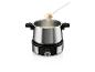 Un set à fondue avec du fromage fondu et un morceau de pain sur une fourchette.