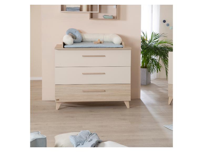 Chambre d'enfant avec commode à langer, étagères et plantes.