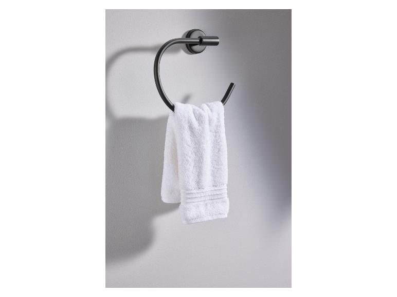 Une serviette blanche accrochée à un porte-serviettes noir mural.