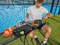 Homme sur terrain de padel, se préparant à jouer avec raquette, sac à dos et balles.