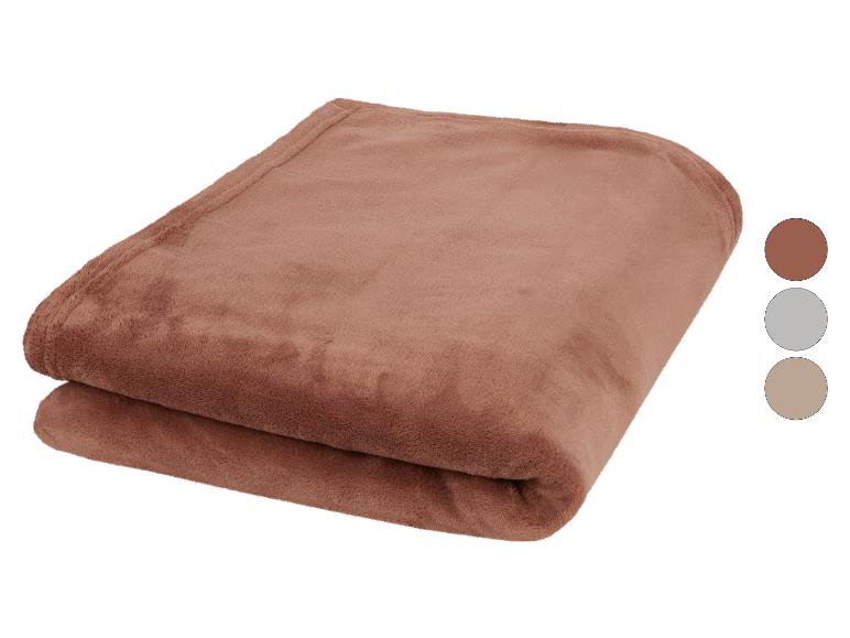 Couverture polaire marron pliée avec des échantillons de couleurs à côté.