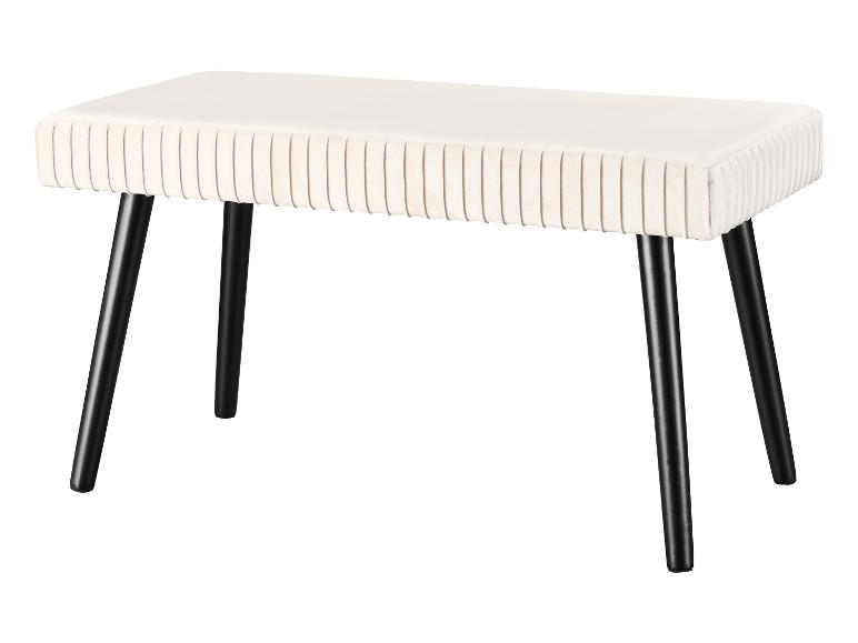 Un banc en velours blanc avec des pieds noirs.