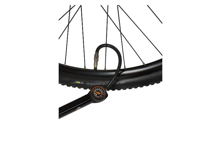 Pompe à vélo avec manomètre connectée à un pneu de vélo noir.