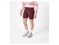 Femme portant un short de cycliste bordeaux et des baskets vert clair.