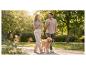 Couple avec golden retriever en promenade dans un parc.
