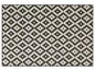 Un tapis tissé noir et blanc avec un motif géométrique.