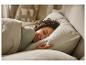 Femme dormant paisiblement dans son lit, couverte d'une couette douce.