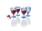Quatre verres à vin bleu, style vintage, remplis de vin rouge.