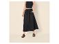Femme en crop top noir, jupe longue et sandales.