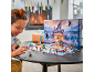 Enfant jouant avec un calendrier de l'Avent de jouets sur une table devant une cheminée.
