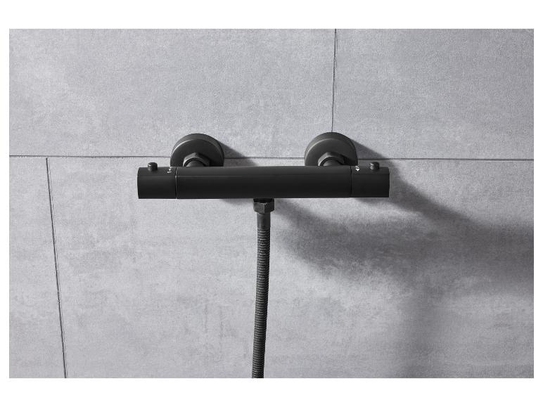 Mitigeur thermostatique de douche noir, fixé au mur.