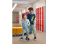 Deux garçons dans un couloir d'école portant des vestes de style teddy et des joggings.